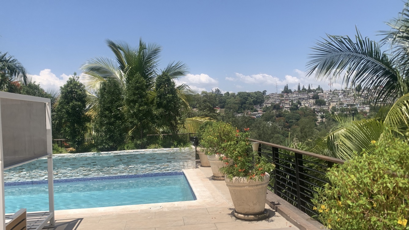 Lavish Furnished Paraseismic Mansion for Sale in Juvenat (Karibe Hotel Green Zone), Port-au-Prince, Haiti – 4 Spacious Bedrooms with Modern High-end Furniture & Appliances, Large Circular Living/Dining Rooms, 3 1/2 Stylish Bathrooms, Gourmet Kitchen, Panoramic Living/Dining Rooms, Gleaming Swimming Pool with Attached Jacuzzi, Multiple Seating Areas, Exclusive/Private Neighborhood, Robust 24/7 Solar-Powered Electricity System, Servant/Security Quarter