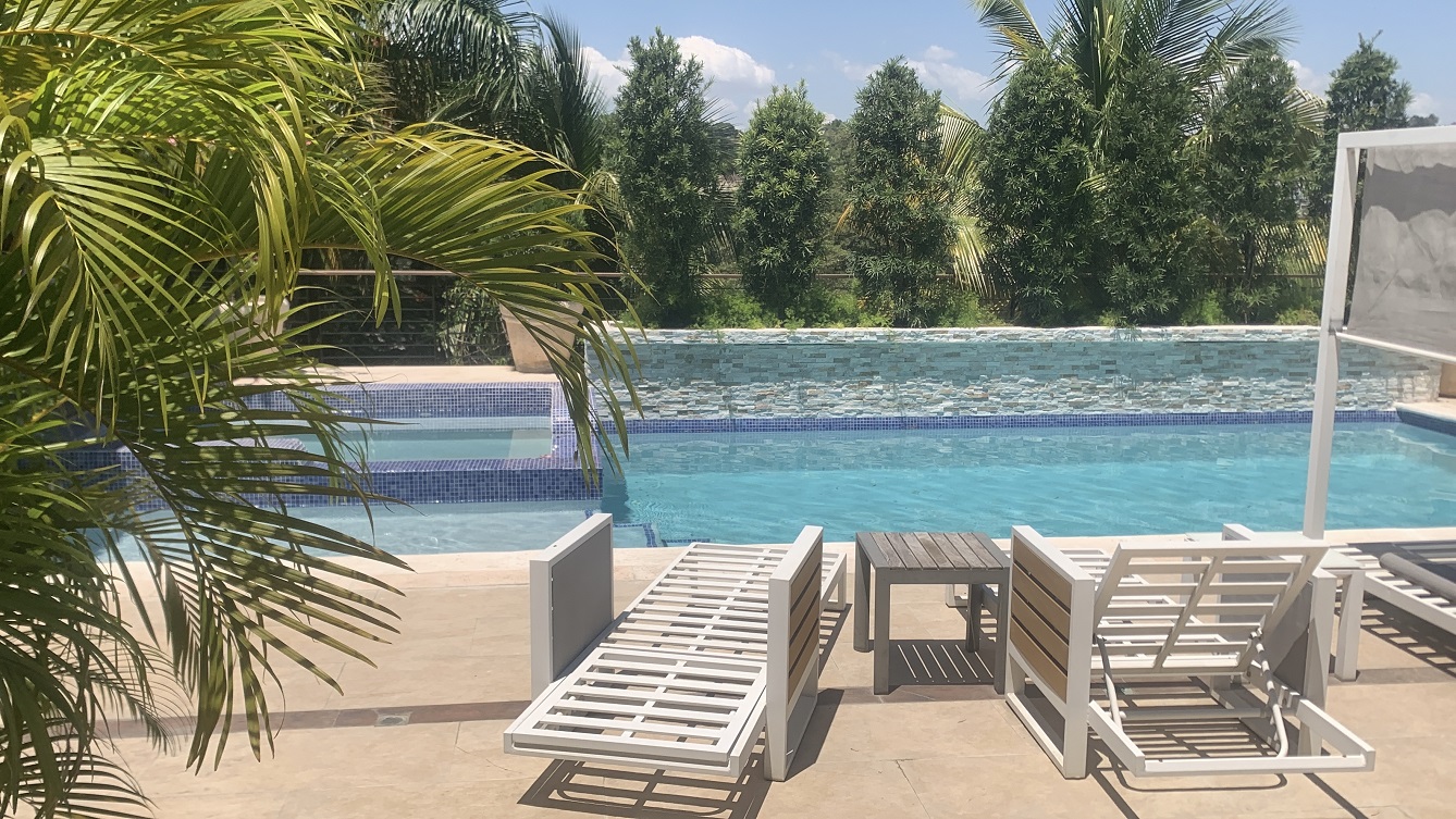Lavish Furnished Paraseismic Mansion for Sale in Juvenat (Karibe Hotel Green Zone), Port-au-Prince, Haiti – 4 Spacious Bedrooms with Modern High-end Furniture & Appliances, Large Circular Living/Dining Rooms, 3 1/2 Stylish Bathrooms, Gourmet Kitchen, Panoramic Living/Dining Rooms, Gleaming Swimming Pool with Attached Jacuzzi, Multiple Seating Areas, Exclusive/Private Neighborhood, Robust 24/7 Solar-Powered Electricity System, Servant/Security Quarter