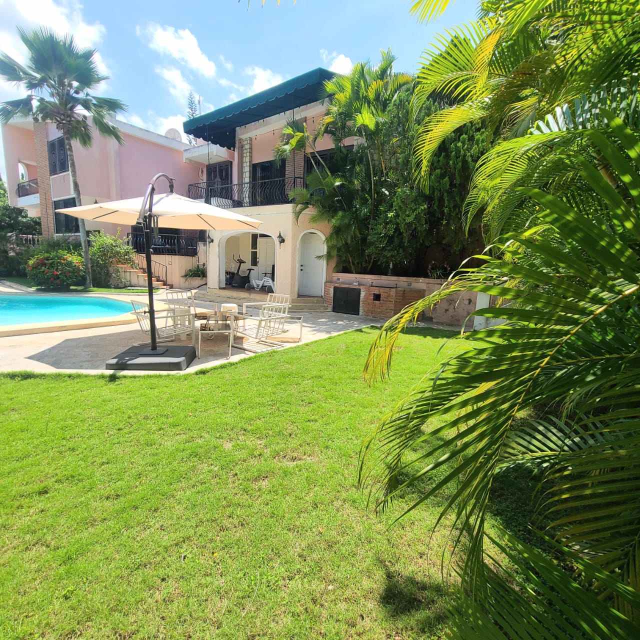 Stunning Furnished House for SALE in Lower Morne Calvaire, Petion-Ville, Haiti – 3 Spacious Bedrooms with Modern High-end Furniture & Appliances, Capacious Living/Dining Rooms, 3 1/2 Stylish Bathrooms, Gourmet Kitchen, Panoramic Living/Dining Rooms, Radiant Swimming Pool with Chairs, Chaise Loungers, & Tables, Multiple Seating Areas, Exclusive/Private Neighborhood, Robust 24/7 Solar-Powered Electricity System, Servant/Security Quarters, Manicure, Lush Green Trees