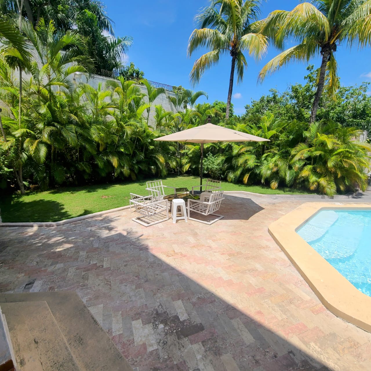 Stunning Furnished House for SALE in Lower Morne Calvaire, Petion-Ville, Haiti – 3 Spacious Bedrooms with Modern High-end Furniture & Appliances, Capacious Living/Dining Rooms, 3 1/2 Stylish Bathrooms, Gourmet Kitchen, Panoramic Living/Dining Rooms, Radiant Swimming Pool with Chairs, Chaise Loungers, & Tables, Multiple Seating Areas, Exclusive/Private Neighborhood, Robust 24/7 Solar-Powered Electricity System, Servant/Security Quarters, Manicure, Lush Green Trees