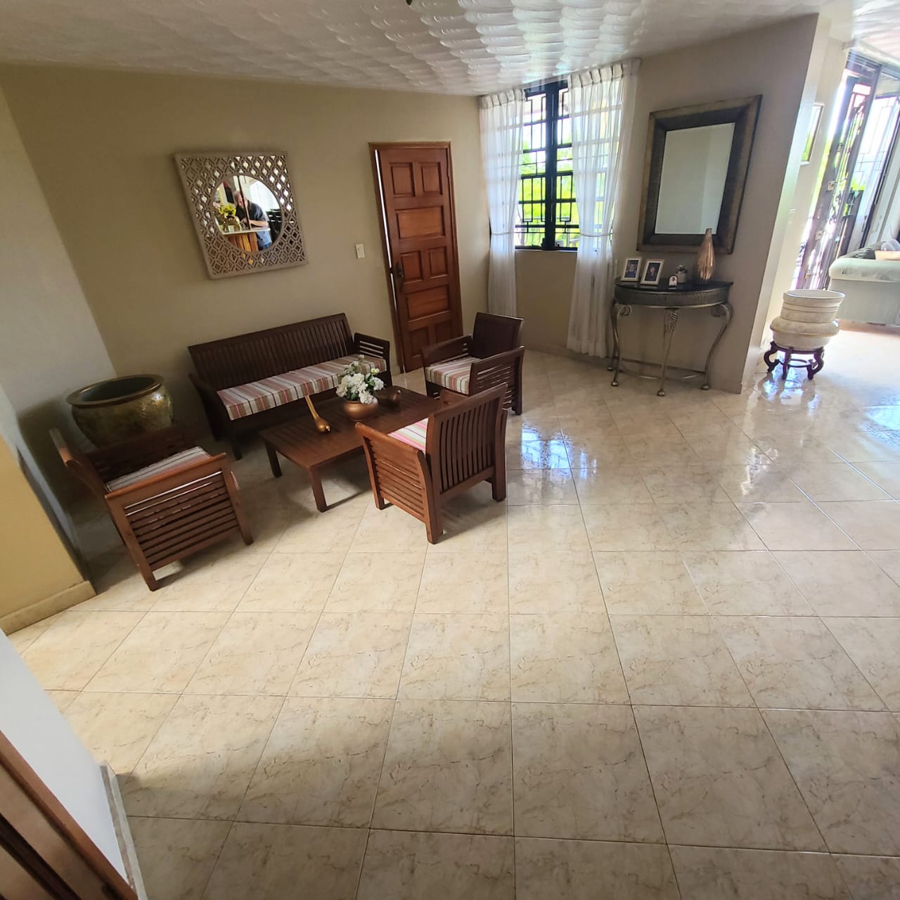 Stunning Furnished House for SALE in Lower Morne Calvaire, Petion-Ville, Haiti – 3 Spacious Bedrooms with Modern High-end Furniture & Appliances, Capacious Living/Dining Rooms, 3 1/2 Stylish Bathrooms, Gourmet Kitchen, Panoramic Living/Dining Rooms, Radiant Swimming Pool with Chairs, Chaise Loungers, & Tables, Multiple Seating Areas, Exclusive/Private Neighborhood, Robust 24/7 Solar-Powered Electricity System, Servant/Security Quarters, Manicure, Lush Green Trees