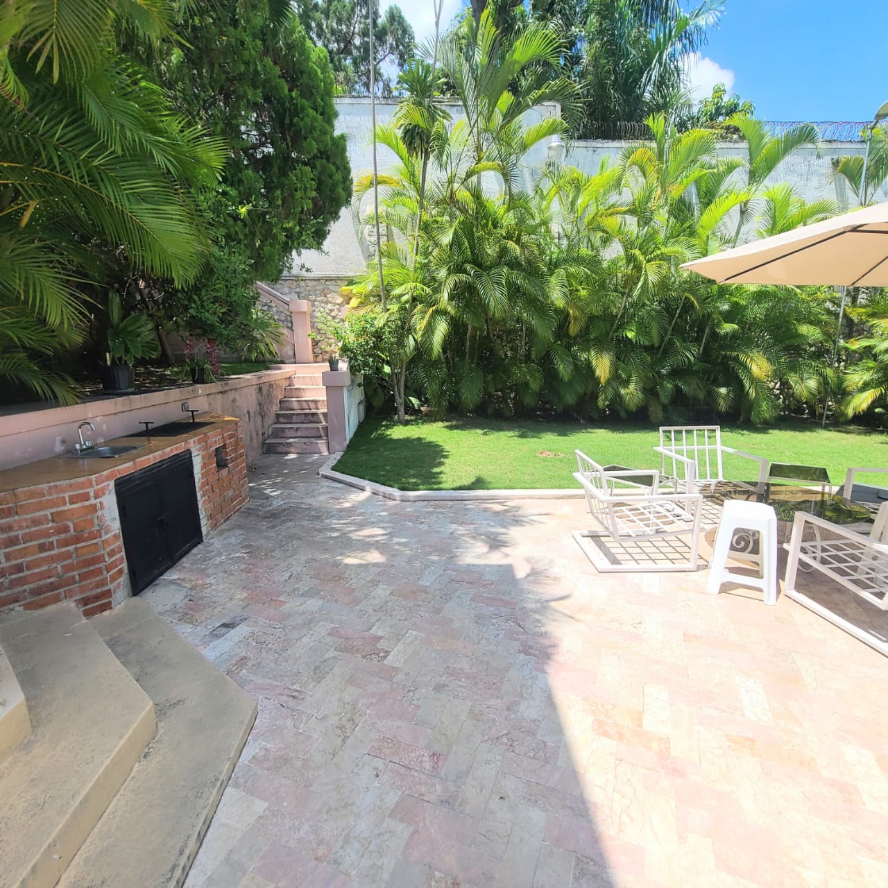 Stunning Furnished House for SALE in Lower Morne Calvaire, Petion-Ville, Haiti – 3 Spacious Bedrooms with Modern High-end Furniture & Appliances, Capacious Living/Dining Rooms, 3 1/2 Stylish Bathrooms, Gourmet Kitchen, Panoramic Living/Dining Rooms, Radiant Swimming Pool with Chairs, Chaise Loungers, & Tables, Multiple Seating Areas, Exclusive/Private Neighborhood, Robust 24/7 Solar-Powered Electricity System, Servant/Security Quarters, Manicure, Lush Green Trees
