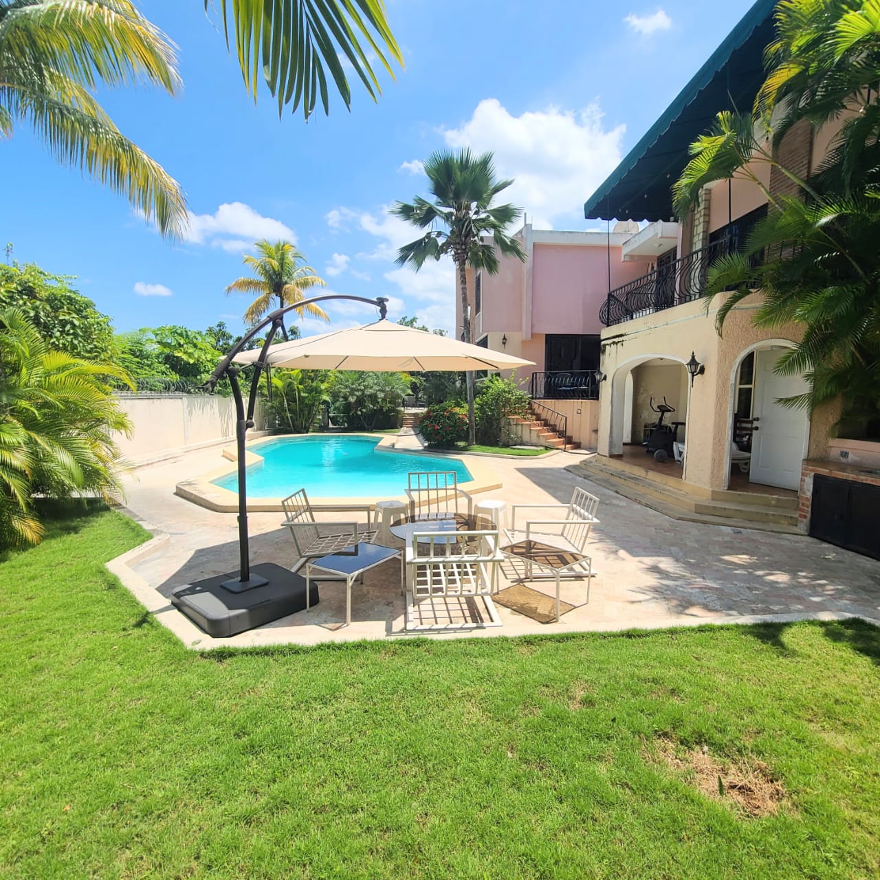 Stunning Furnished House for SALE in Lower Morne Calvaire, Petion-Ville, Haiti – 3 Spacious Bedrooms with Modern High-end Furniture & Appliances, Capacious Living/Dining Rooms, 3 1/2 Stylish Bathrooms, Gourmet Kitchen, Panoramic Living/Dining Rooms, Radiant Swimming Pool with Chairs, Chaise Loungers, & Tables, Multiple Seating Areas, Exclusive/Private Neighborhood, Robust 24/7 Solar-Powered Electricity System, Servant/Security Quarters, Manicure, Lush Green Trees