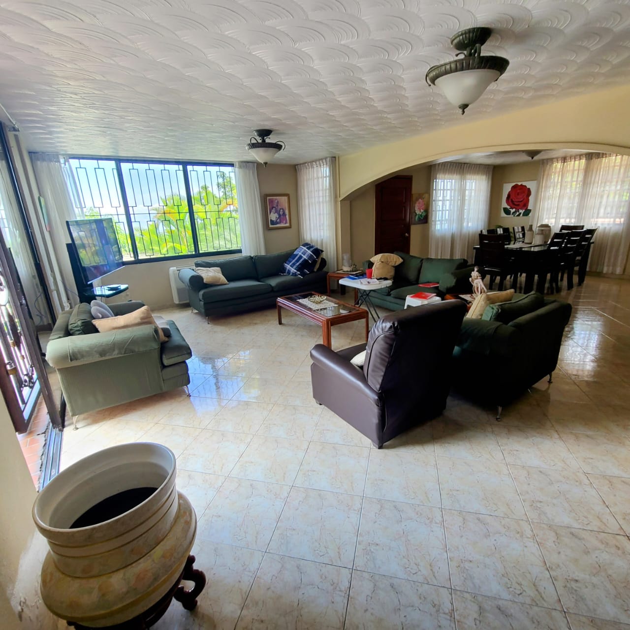 Stunning Furnished House for SALE in Lower Morne Calvaire, Petion-Ville, Haiti – 3 Spacious Bedrooms with Modern High-end Furniture & Appliances, Capacious Living/Dining Rooms, 3 1/2 Stylish Bathrooms, Gourmet Kitchen, Panoramic Living/Dining Rooms, Radiant Swimming Pool with Chairs, Chaise Loungers, & Tables, Multiple Seating Areas, Exclusive/Private Neighborhood, Robust 24/7 Solar-Powered Electricity System, Servant/Security Quarters, Manicure, Lush Green Trees