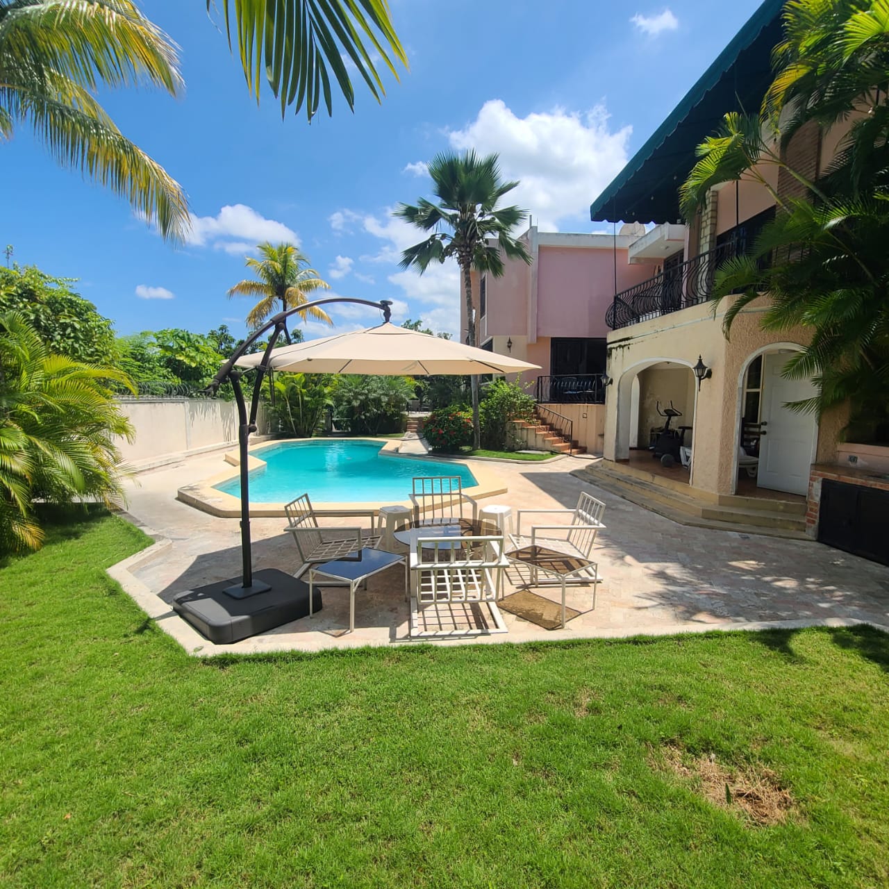Stunning Furnished House for SALE in Lower Morne Calvaire, Petion-Ville, Haiti – 3 Spacious Bedrooms with Modern High-end Furniture & Appliances, Capacious Living/Dining Rooms, 3 1/2 Stylish Bathrooms, Gourmet Kitchen, Panoramic Living/Dining Rooms, Radiant Swimming Pool with Chairs, Chaise Loungers, & Tables, Multiple Seating Areas, Exclusive/Private Neighborhood, Robust 24/7 Solar-Powered Electricity System, Servant/Security Quarters, Manicure, Lush Green Trees