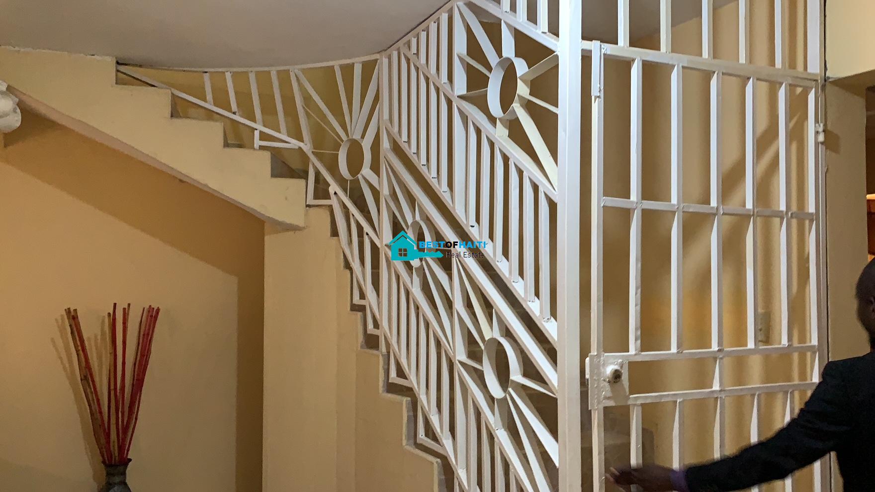 Beautiful, 3-Story, Mega Furnished House For Sale in Santo 17, Port-au-Prince, Haiti – 8 Spacious Bedrooms with Walk-in Closets, 7 Bathrooms, Multiple Living & Dining Rooms, Modern Kitchen, Floor-to-Ceiling Windows, Several Balconies, Servant Quarters, Big Yards/Gardens, 80-foot Artesian Well, High Fences, 2 Iron Gates, Lots of Parking Spaces
