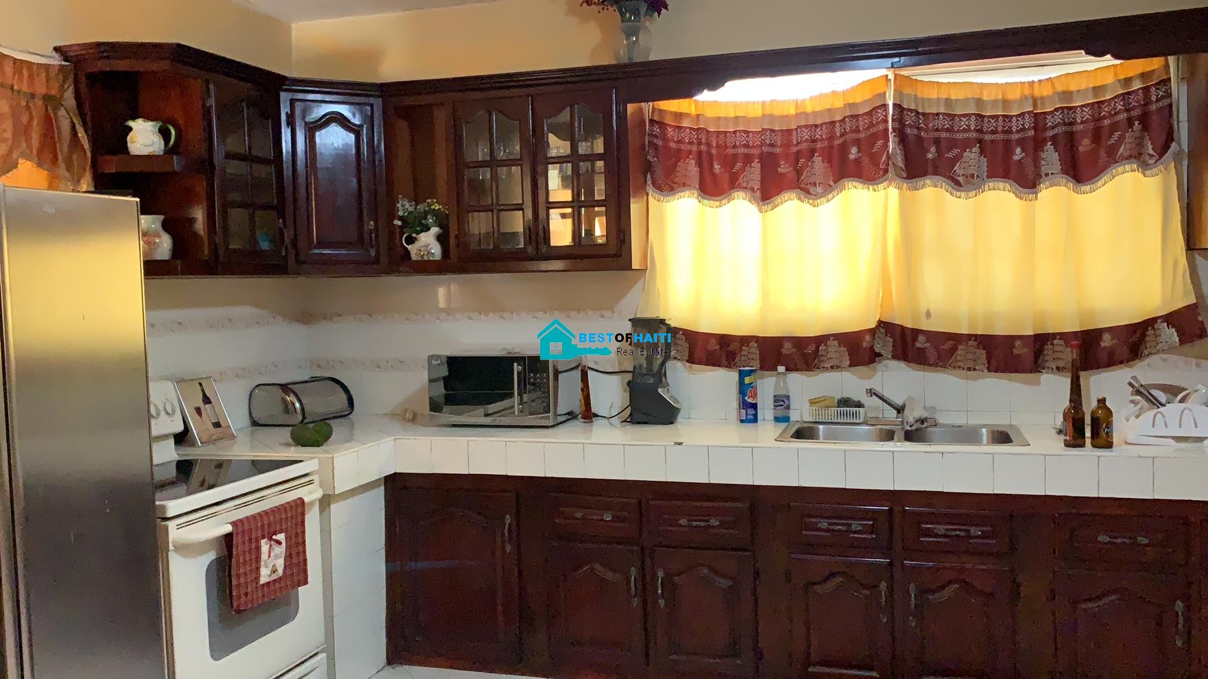 Beautiful, 3-Story, Mega Furnished House For Sale in Santo 17, Port-au-Prince, Haiti – 8 Spacious Bedrooms with Walk-in Closets, 7 Bathrooms, Multiple Living & Dining Rooms, Modern Kitchen, Floor-to-Ceiling Windows, Several Balconies, Servant Quarters, Big Yards/Gardens, 80-foot Artesian Well, High Fences, 2 Iron Gates, Lots of Parking Spaces