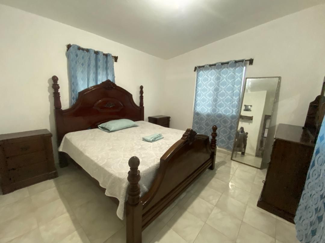Move-in Ready Furnished Apartment for RENT in Petite Anse, Cap-Haïtien, Haiti – 2 Bedrooms, 1 Bathroom, Living/Dining Rooms with Clean Furniture & Appliances, Modern Kitchen, Large Upper Balcony with Views, Fans, Washer/Dryer, High-Speed Internet, Television (TV), Solar-Powered Electricity, Indoor Parking for 1 Car