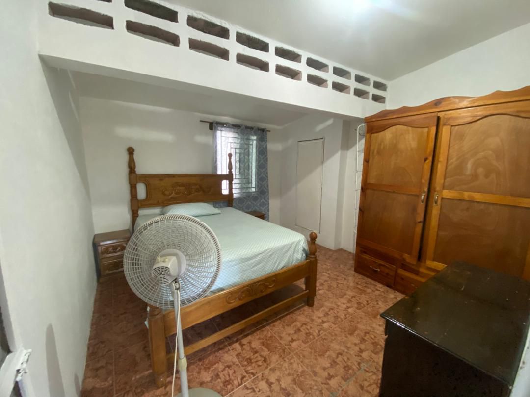 Move-in Ready Furnished Apartment for RENT in Petite Anse, Cap-Haïtien, Haiti – 2 Bedrooms, 1 Bathroom, Living/Dining Rooms with Clean Furniture & Appliances, Modern Kitchen, Large Upper Balcony with Views, Fans, Washer/Dryer, High-Speed Internet, Television (TV), Solar-Powered Electricity, Indoor Parking for 1 Car