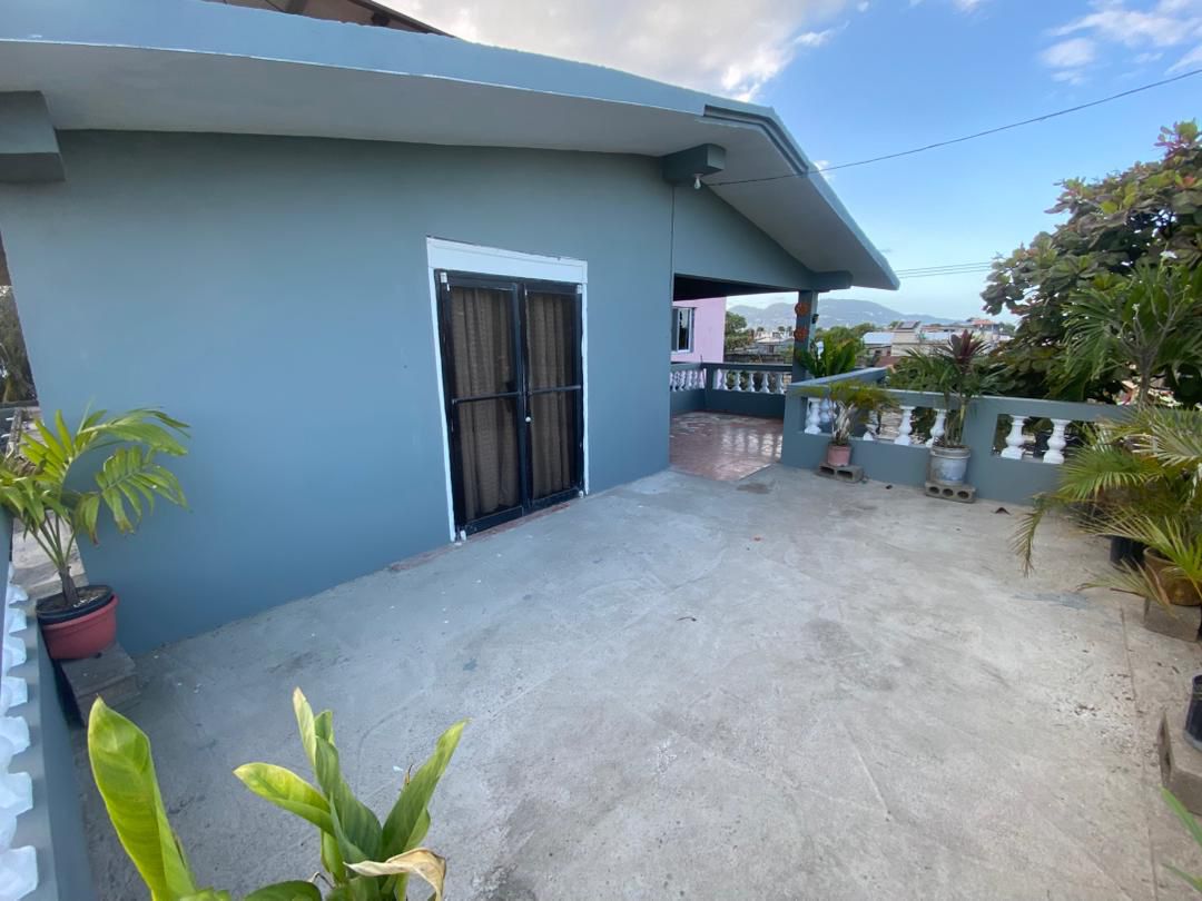 Move-in Ready Furnished Apartment for RENT in Petite Anse, Cap-Haïtien, Haiti – 2 Bedrooms, 1 Bathroom, Living/Dining Rooms with Clean Furniture & Appliances, Modern Kitchen, Large Upper Balcony with Views, Fans, Washer/Dryer, High-Speed Internet, Television (TV), Solar-Powered Electricity, Indoor Parking for 1 Car