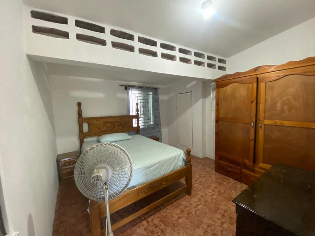 Move-in Ready Furnished Apartment for RENT in Petite Anse, Cap-Haïtien, Haiti – 2 Bedrooms, 1 Bathroom, Living/Dining Rooms with Clean Furniture & Appliances, Modern Kitchen, Large Upper Balcony with Views, Fans, Washer/Dryer, High-Speed Internet, Television (TV), Solar-Powered Electricity, Indoor Parking for 1 Car